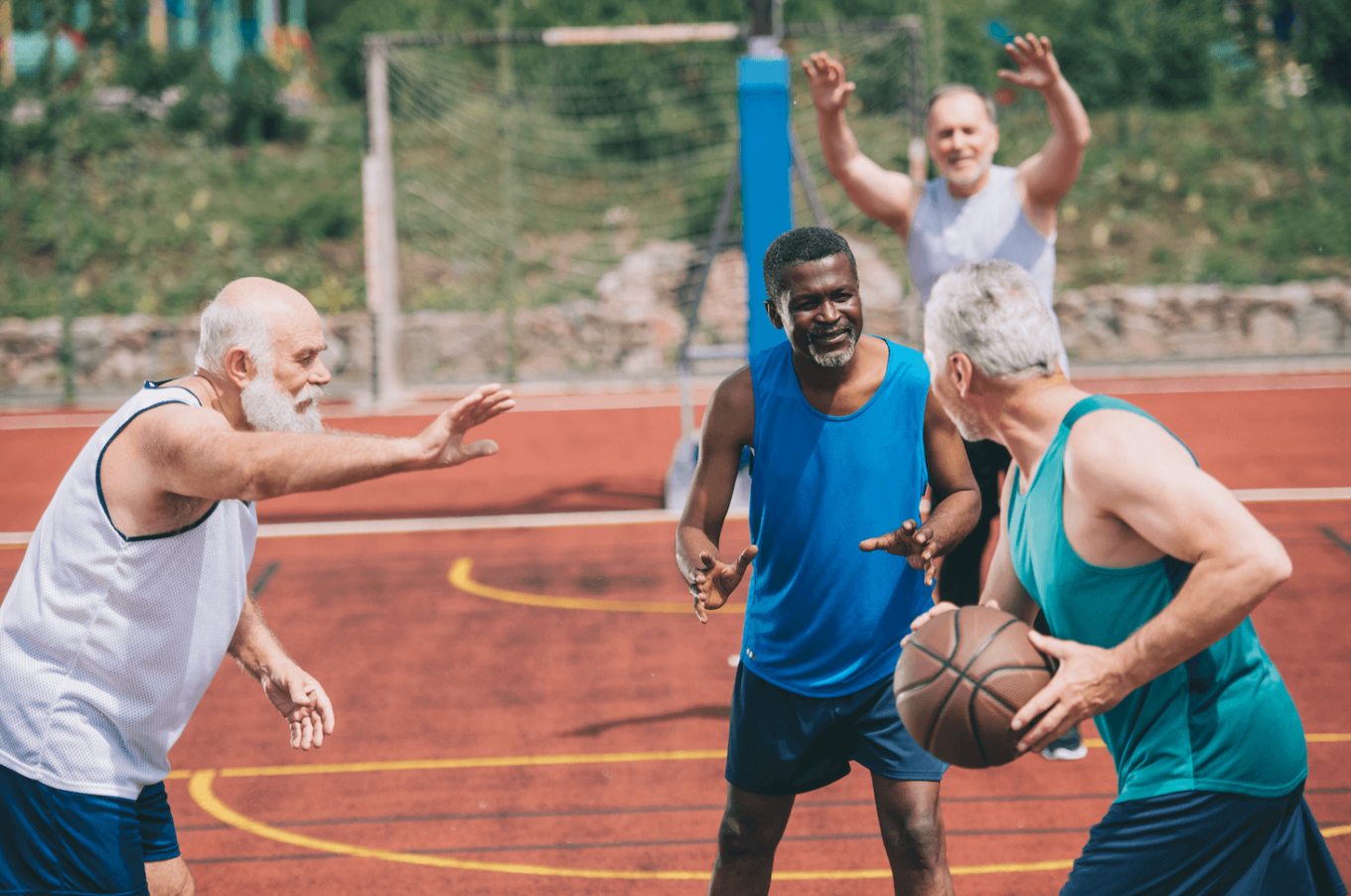 Interracial elderly sportsmen playing basketball together on playground by LightFieldStudios